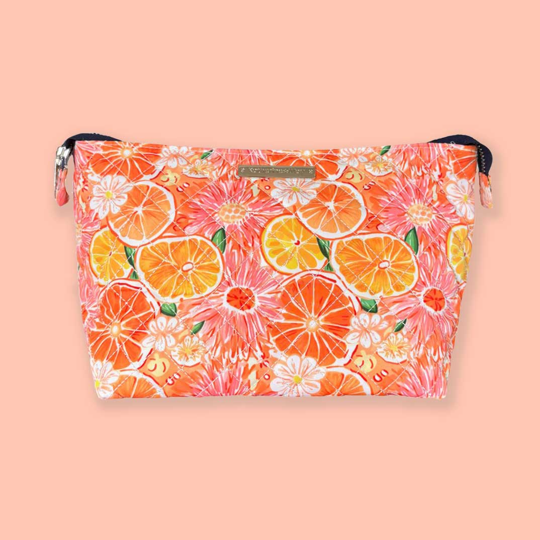 A large zippered cosmetics pouch with a citrus and dahlia pattern in orange, pink, and white colors.
